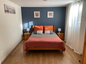 um quarto com uma cama com paredes azuis e pisos em madeira em Netmust vacances em Saint-Palais-sur-Mer