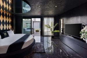 a bedroom with a large bed and a tv at H Hotel & SPA - Adults Only in St. Julianʼs