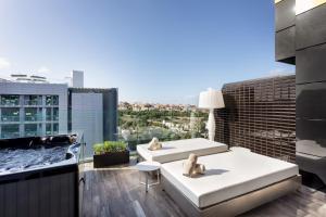 a balcony with two couches and a hot tub at H Hotel & SPA - Adults Only in St. Julianʼs