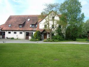 ein großes weißes Haus mit einem großen Rasenhof in der Unterkunft Ferienwohnung Neureuth in Schillingsfürst