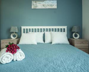 グダニスクにあるPelican Roomsの青いベッドルーム(タオル、花付)