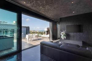 a living room with a couch and a television at H Hotel & SPA - Adults Only in St. Julianʼs