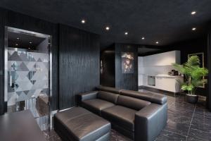 a living room with a leather couch and a table at H Hotel & SPA - Adults Only in St. Julianʼs