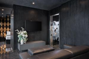 a living room with a couch and a tv on a wall at H Hotel & SPA - Adults Only in St. Julianʼs