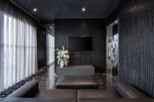 a lobby with a television and a couch and flowers at H Hotel & SPA - Adults Only in St. Julianʼs
