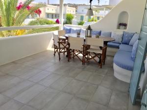 a patio with a table and chairs and a couch at Anthos House in Ornos