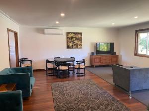 a living room with a table and chairs and a tv at Valley House in Margaret River Town