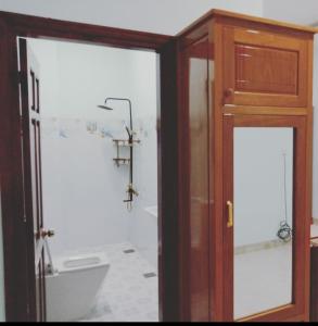 a bathroom with a toilet and a wooden cabinet at Khách sạn Nghinh Phong Beach Tuy Hòa in Tuy Hoa