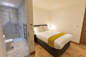 um quarto com uma cama e uma casa de banho com um chuveiro em Marylebone Apartments em Londres