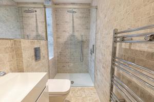 uma casa de banho com um chuveiro, um WC e um lavatório. em Marylebone Apartments em Londres