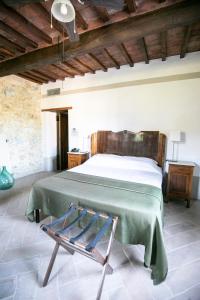 een slaapkamer met een groot bed en een stoel bij B&B Locanda Toscanini in Cetona