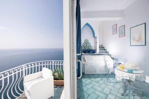 sypialnia z łóżkiem i balkonem z widokiem na ocean w obiekcie Hotel La Ninfa w Amalfi