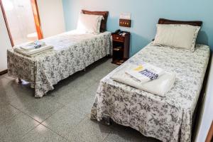 a room with two beds and a table at Pousada Paraiso in Guanambi