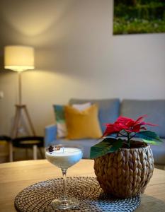uma bebida sobre uma mesa ao lado de um vaso com uma flor em Riga A new designed cosy family apartment em Riga