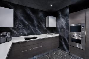 a kitchen with a black marble wall at H Hotel & SPA - Adults Only in St. Julianʼs