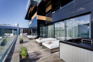 a balcony of a building with benches and tables at H Hotel & SPA - Adults Only in St. Julianʼs