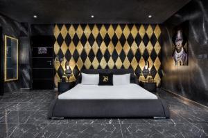 a bedroom with a large bed with a black and gold wall at H Hotel & SPA - Adults Only in St. Julianʼs