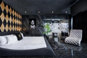a bedroom with a large white bed and a chair at H Hotel & SPA - Adults Only in St. Julianʼs