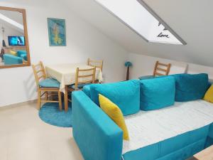 a blue couch in a living room with a table at Apartman Santorini in Novi Sad
