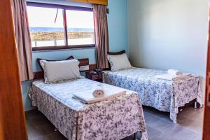 a room with two beds and a window at Pousada Paraiso in Guanambi