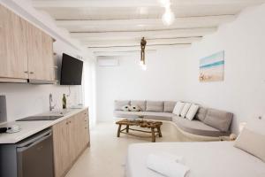 uma cozinha e uma sala de estar com um sofá em Gorgeous Studio In Cycladic Architecture Overlooking The Aegean em Houlakia