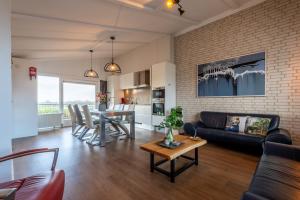 a living room with a couch and a table at Ostreahof Gezin & Familie vakantiehuis aan strand en jachthaven in Kamperland