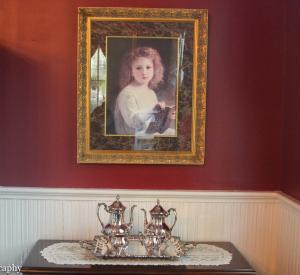 a painting of a little girl in a painting on a wall at Flowertown Bed and Breakfast in Summerville