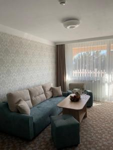a living room with a blue couch and a table at Balneo & SPA Hotel Aura in Velingrad
