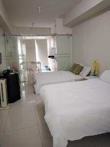 um quarto com três camas e uma cozinha em Wind Residences Tagaytay em Tagaytay