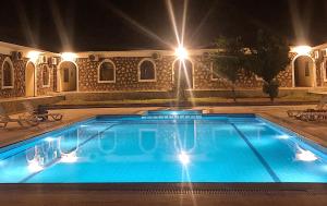 a swimming pool at night with a fountain at Hotel Euphrat Nemrut in Karadut