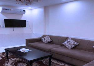een woonkamer met een bank en een tafel bij روائع الأحلام للاجنحة الفندقية in Jeddah