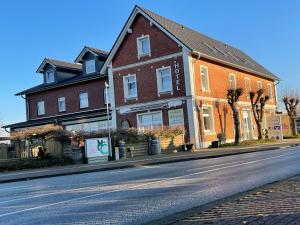 a large brick house on a city street at Hotel Frederikspark in Norderstedt