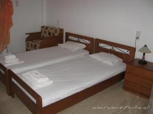 two twin beds in a bedroom with a dresser at Psaros Melinta in Plomari