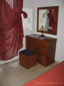 a bedroom with a dresser and a mirror at Psaros Melinta in Plomari