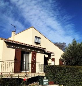 une maison blanche avec une clôture devant elle dans l'établissement Maison des clairettes entre Camargue, Arles & Nîmes, à Bellegarde