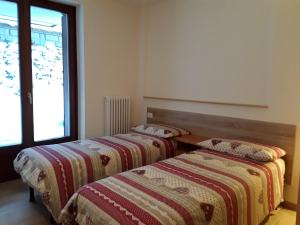two beds sitting next to each other in a room at Apartments "STELLA ALPINA" in Santa Caterina Valfurva