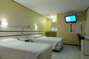 Hotel Elevado في بورتو أليغري: غرفة فندق بها سريران وتلفزيون بشاشة مسطحة