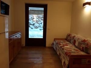 a living room with a couch and a door at Apartments "STELLA ALPINA" in Santa Caterina Valfurva