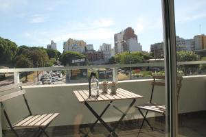 a table and chairs on a balcony with a view of a city at Barrancas de Madero in Buenos Aires