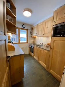 a small kitchen with wooden cabinets and a sink at Hurlebise 8 in Verbier