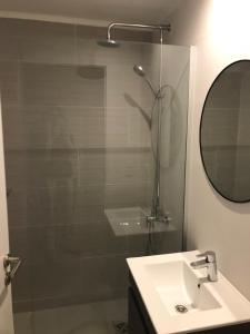 a bathroom with a shower and a sink and a mirror at Departamento Lipari Mar del Plata Deluxe in Mar del Plata