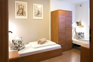 カルパチにあるApartament "AURUM"のベッド1台と木製キャビネット付きの小さな客室です。