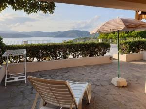 a patio with a table and an umbrella and chairs at Appartamenti Il Sogno in Capoliveri