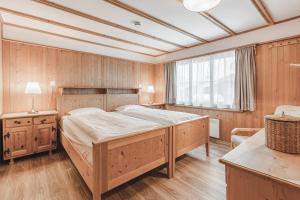 ein Schlafzimmer mit einem großen Bett und Holzwänden in der Unterkunft Chalet Sunna Höckli - Pistennah und Ruhig mit Panoramablick in Arosa