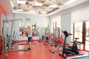 a man in a gym with several tread machines at Arcada Apartments in Odesa