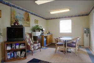 a living room with a table and a tv at America's Best Value Inn - Loudon in Loudon