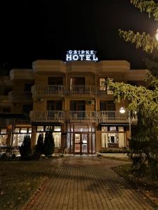 un hotel por la noche con un letrero iluminado en Csipke Hotel en Kiskunhalas