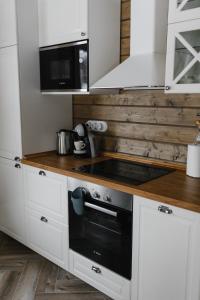 uma cozinha com armários brancos e um forno com placa de fogão em Forrest Lodge Karelia em Reuskula