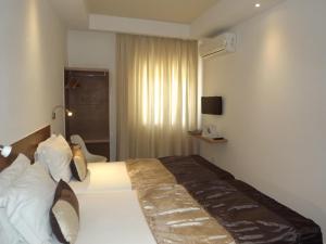拉古什的住宿－瑪阿祖爾酒店，酒店客房配有一张带白色枕头的大床