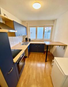 cocina con armarios azules y suelo de madera en Gemütliches WG-Zimmer 4, zentral in Ravensburg (stadtnah), Balkon, en Ravensburg
